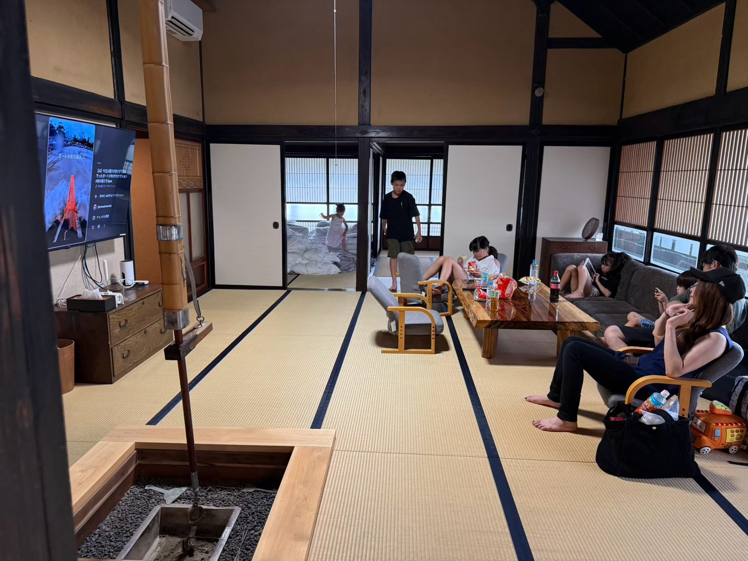 テレビのある畳の部屋でくつろぐ大人と子ども